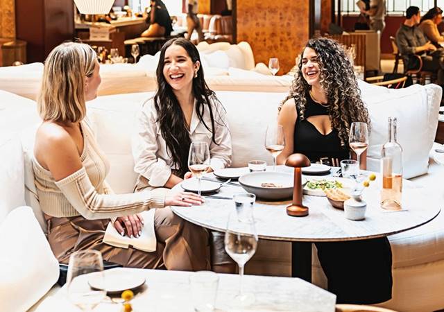 Three women eating and drinking in Lyle's Restaurant and Bar