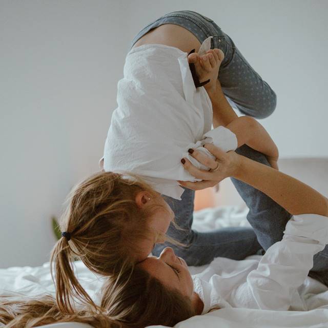 Mother and child playing on bed