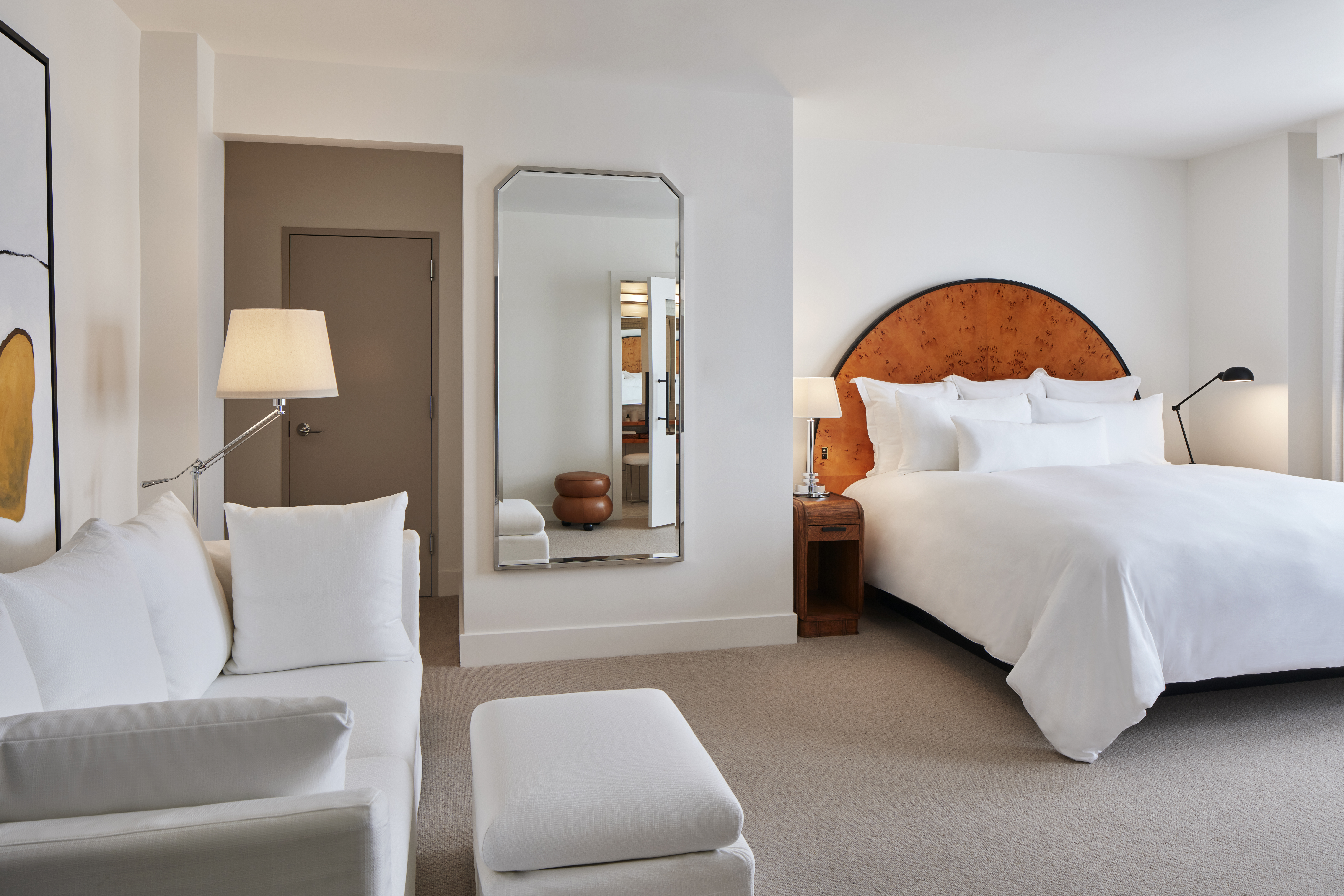 Deluxe King room at Lyle DC with a comfortable bed, white sofa and modern amenities.